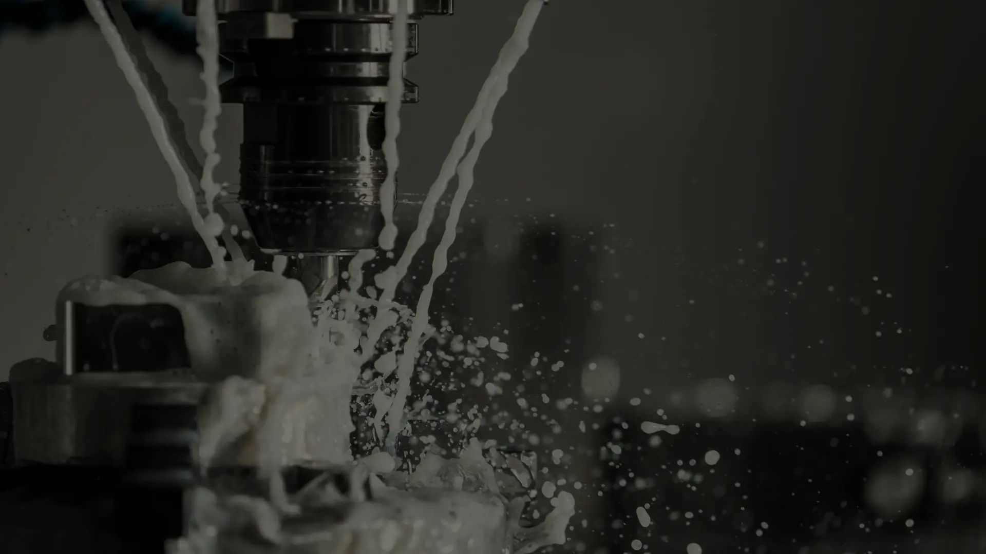 A metal part being machined under coolant